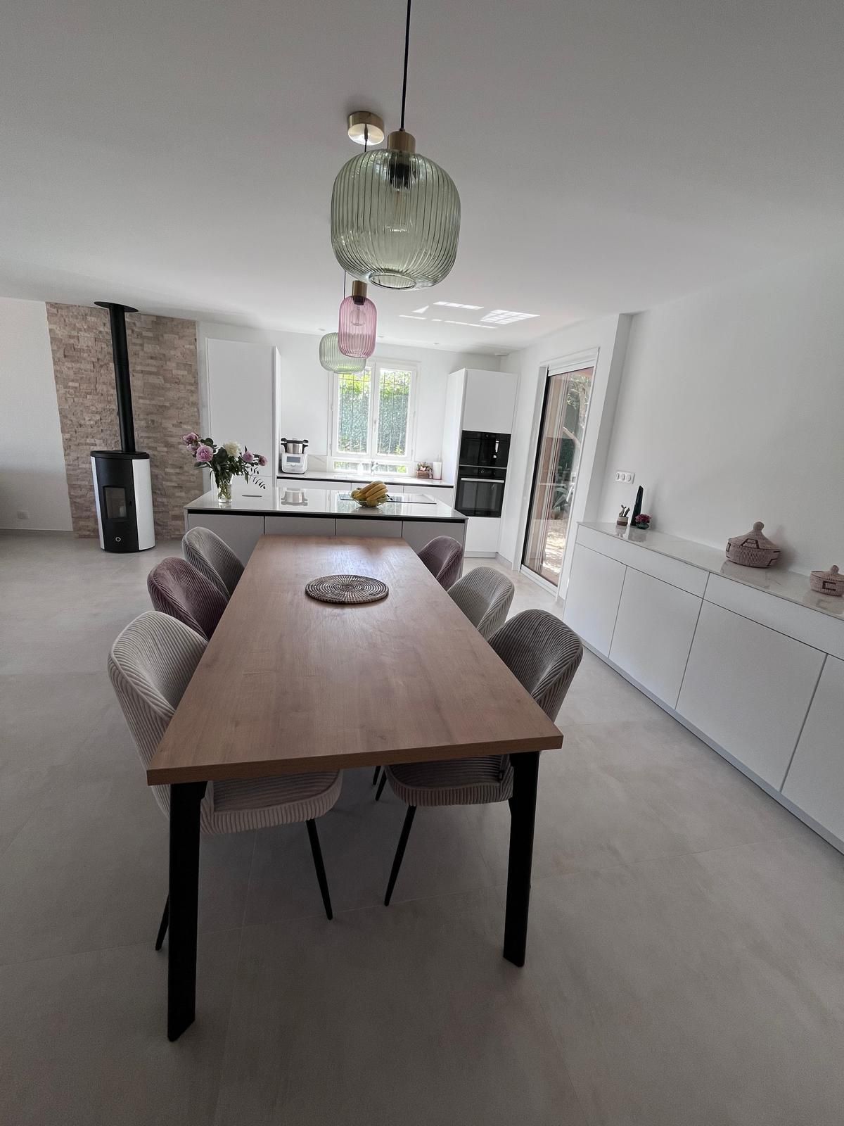 Une salle à manger avec une longue table en bois et des chaises.