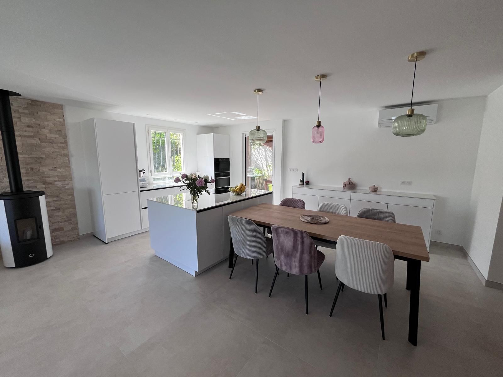 Il y a une table et des chaises au milieu de la pièce.