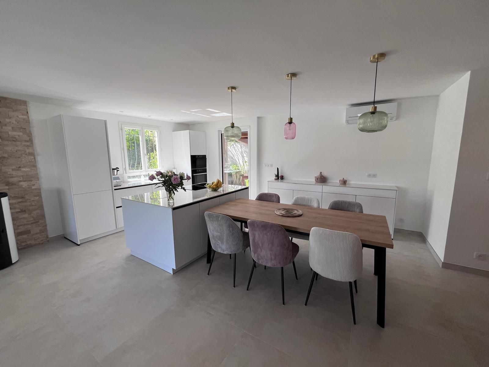 Il y a une table et des chaises au milieu de la pièce.