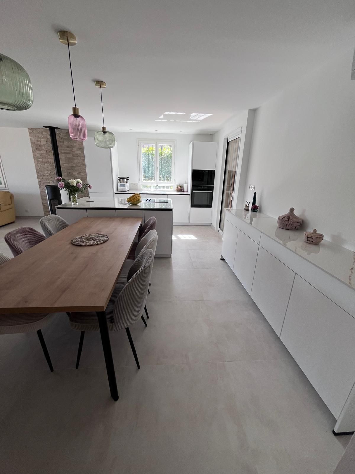 Il y a une table et des chaises au milieu de la pièce.