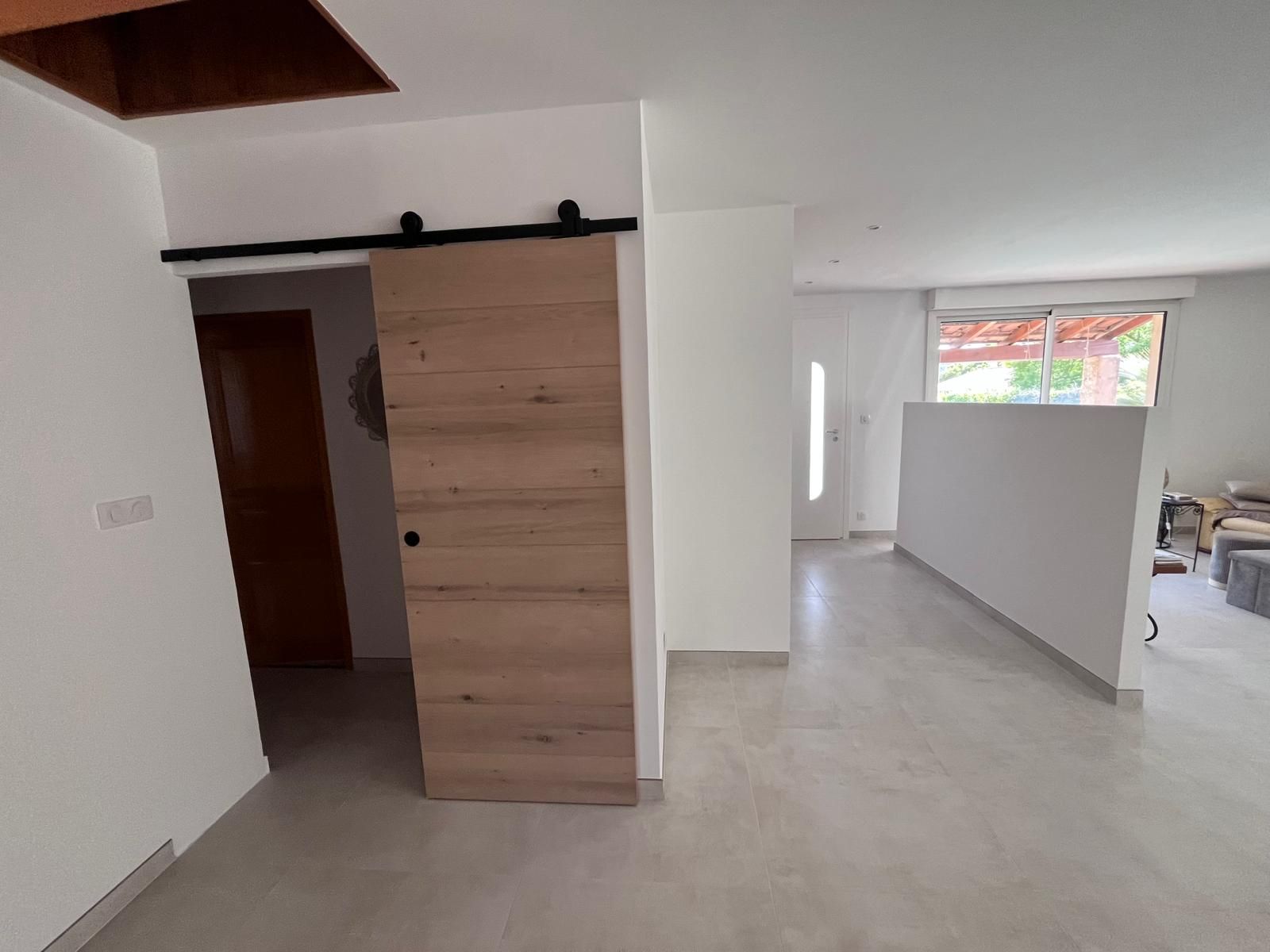 Il y a une porte de grange coulissante au milieu de la pièce.