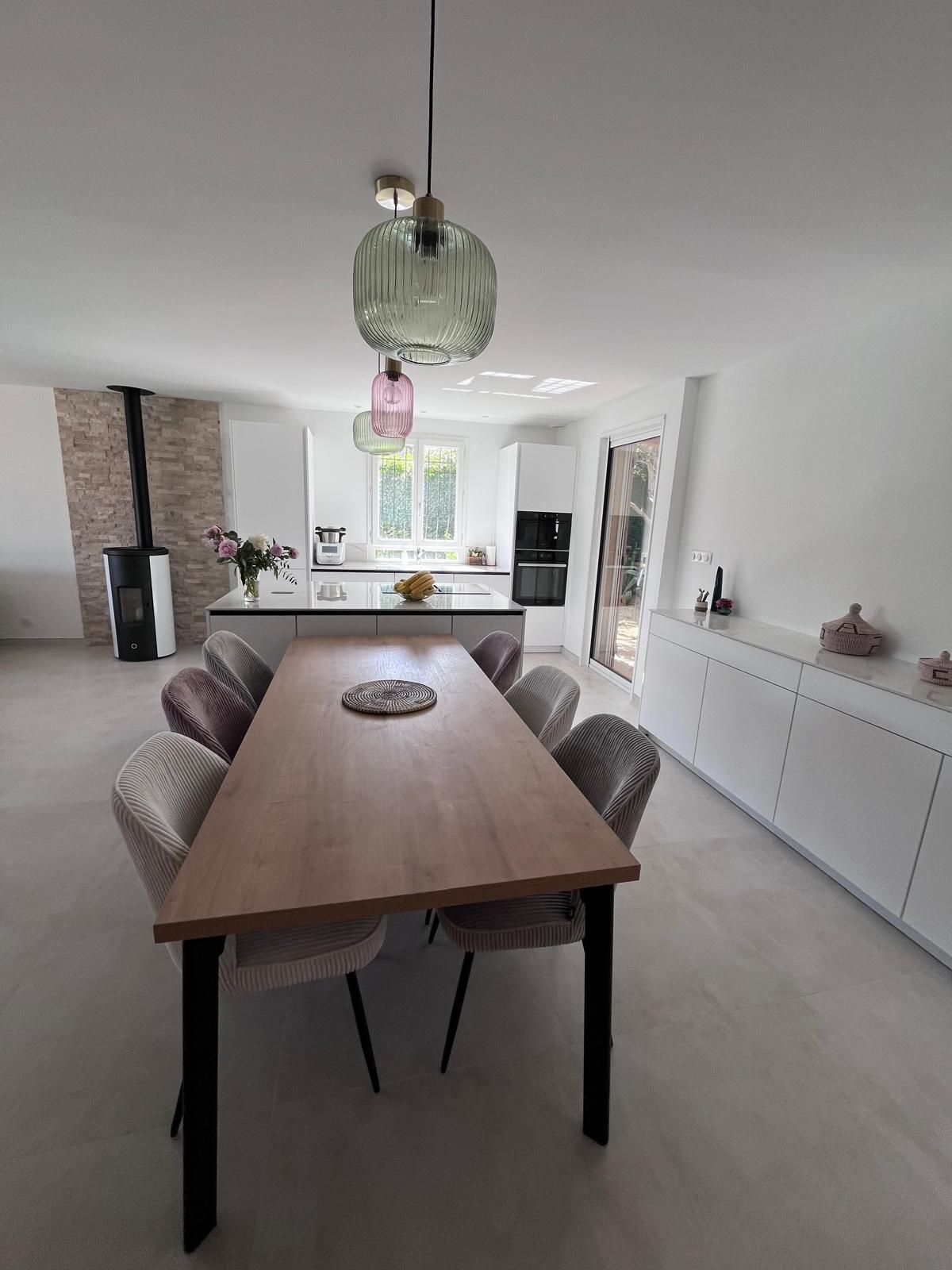Une grande table en bois avec des chaises dans une cuisine.