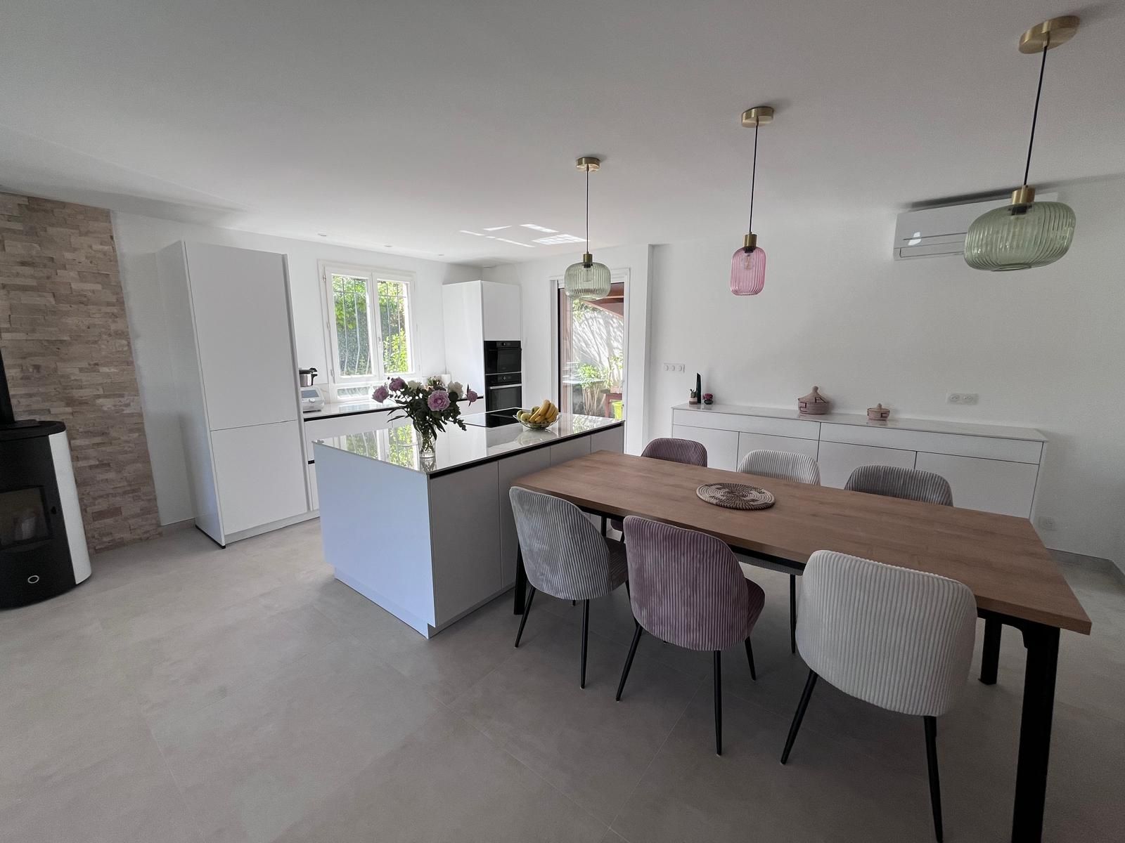 Il y a une table et des chaises au milieu de la pièce.