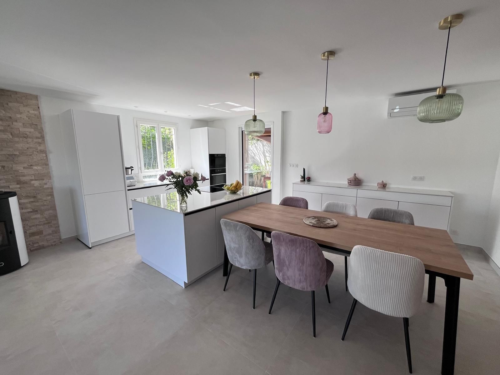 Il y a une table à manger et des chaises au milieu de la pièce.