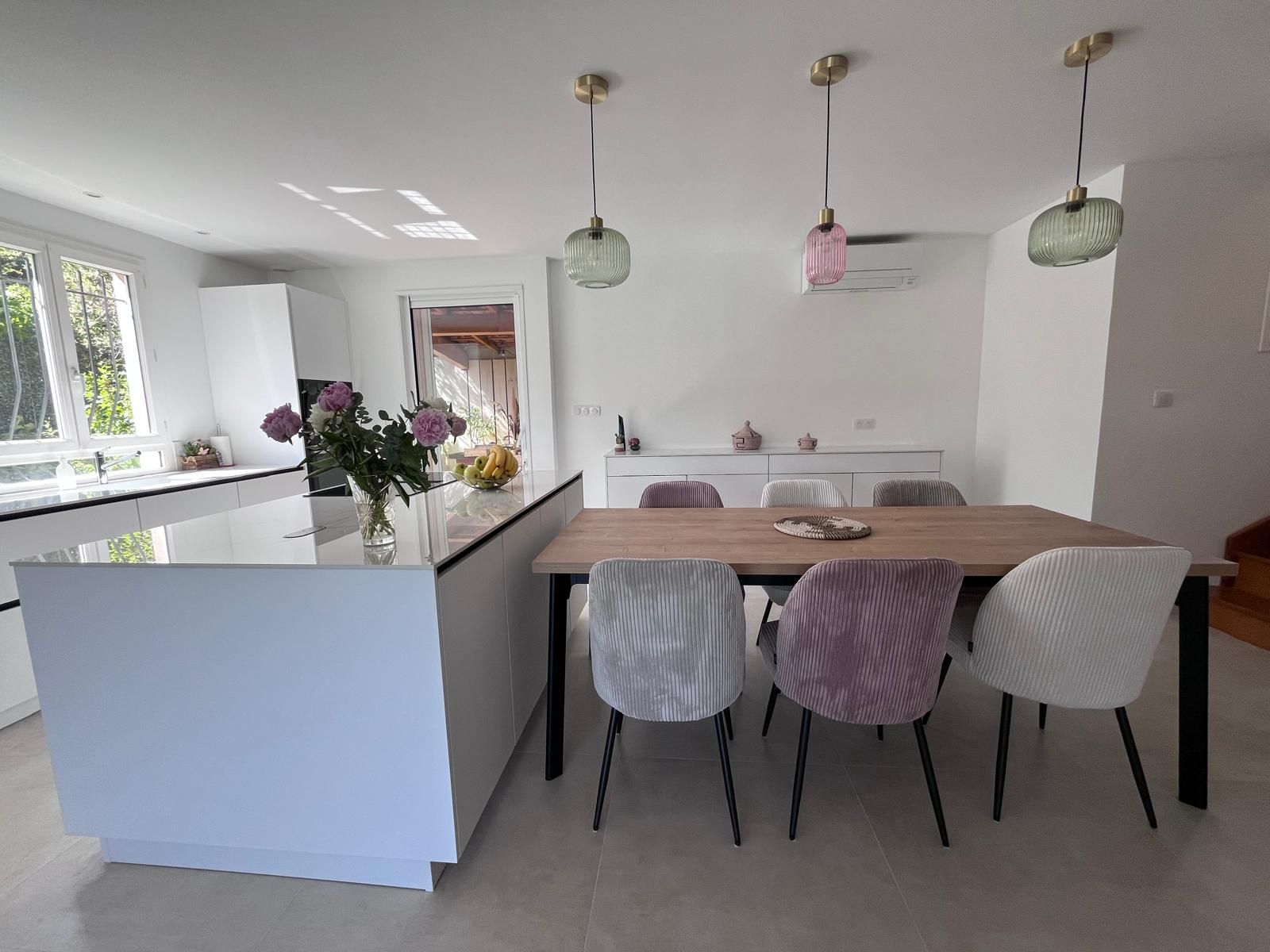 Un petit salon avec un canapé, une table basse et une porte coulissante. Blanc et couleurs neutres.