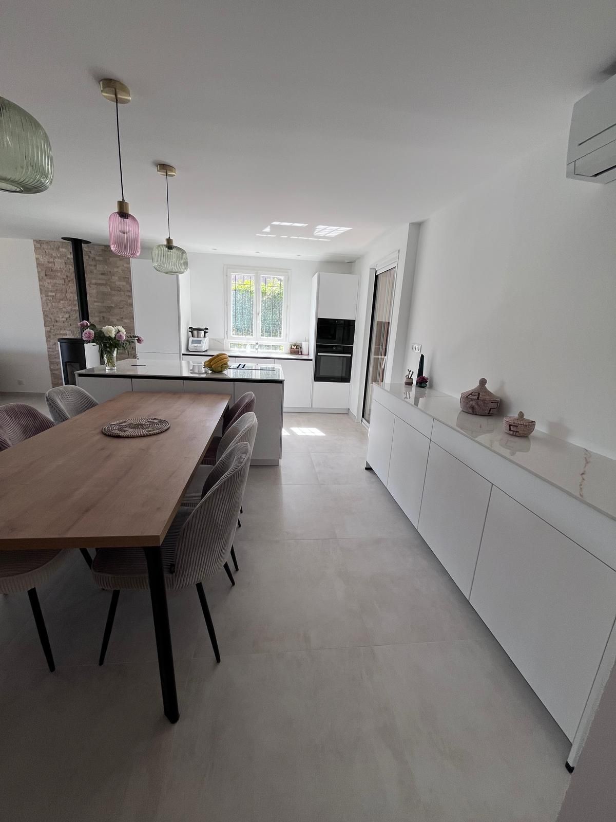 Une cuisine avec une table en bois et des chaises.