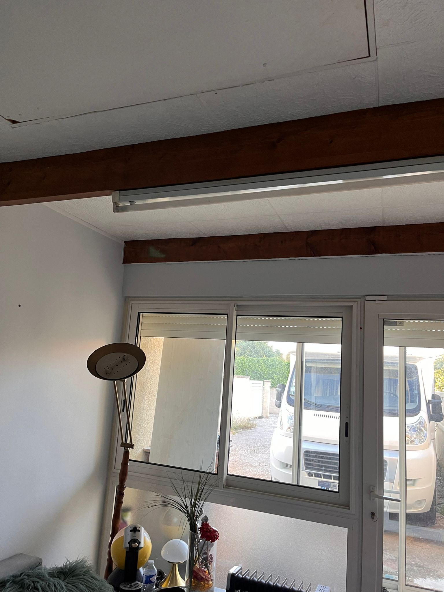 Un salon avec une grande fenêtre et une lampe