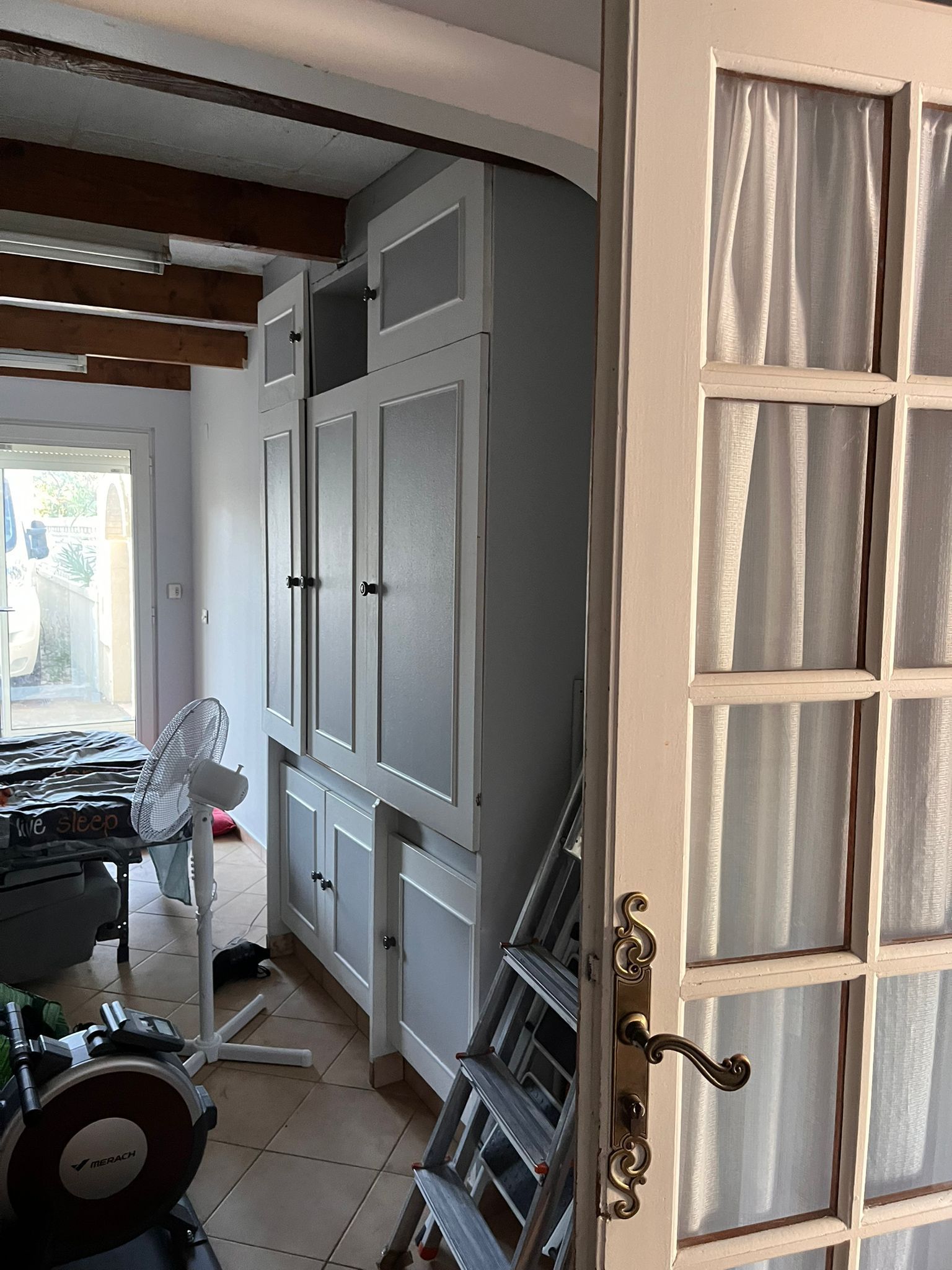 Une échelle est posée dans une pièce à côté d'une porte.