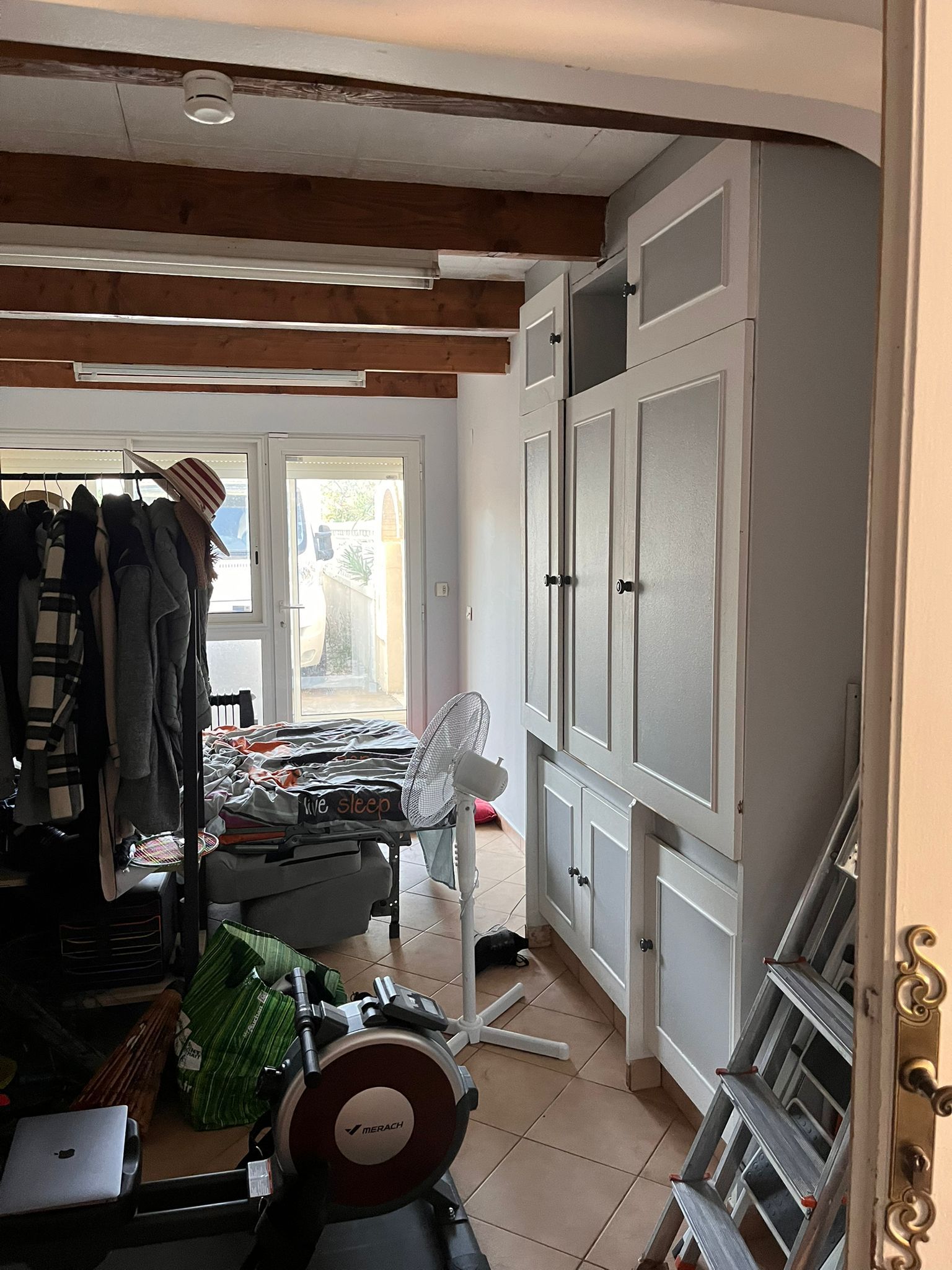 Une pièce avec beaucoup de meubles et une échelle dedans.