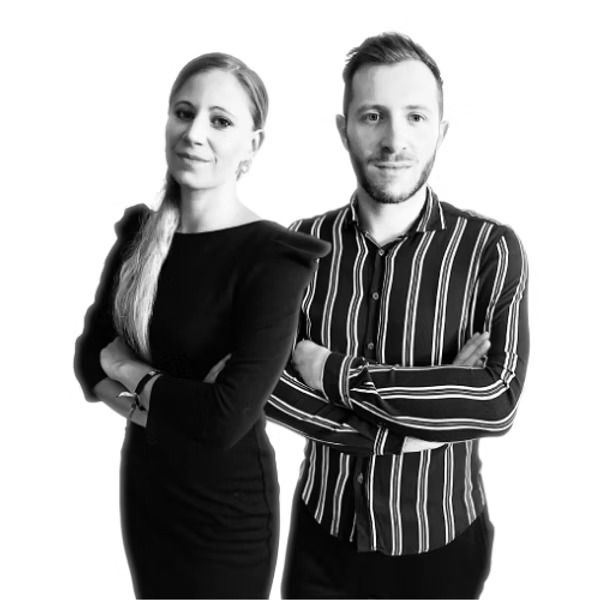 Un homme et une femme se tiennent l'un à côté de l'autre, les bras croisés.