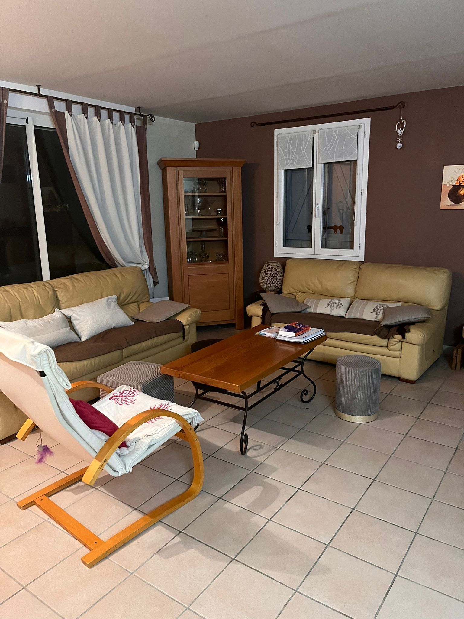 Un salon avec un canapé, une chaise, une table basse et une fenêtre.