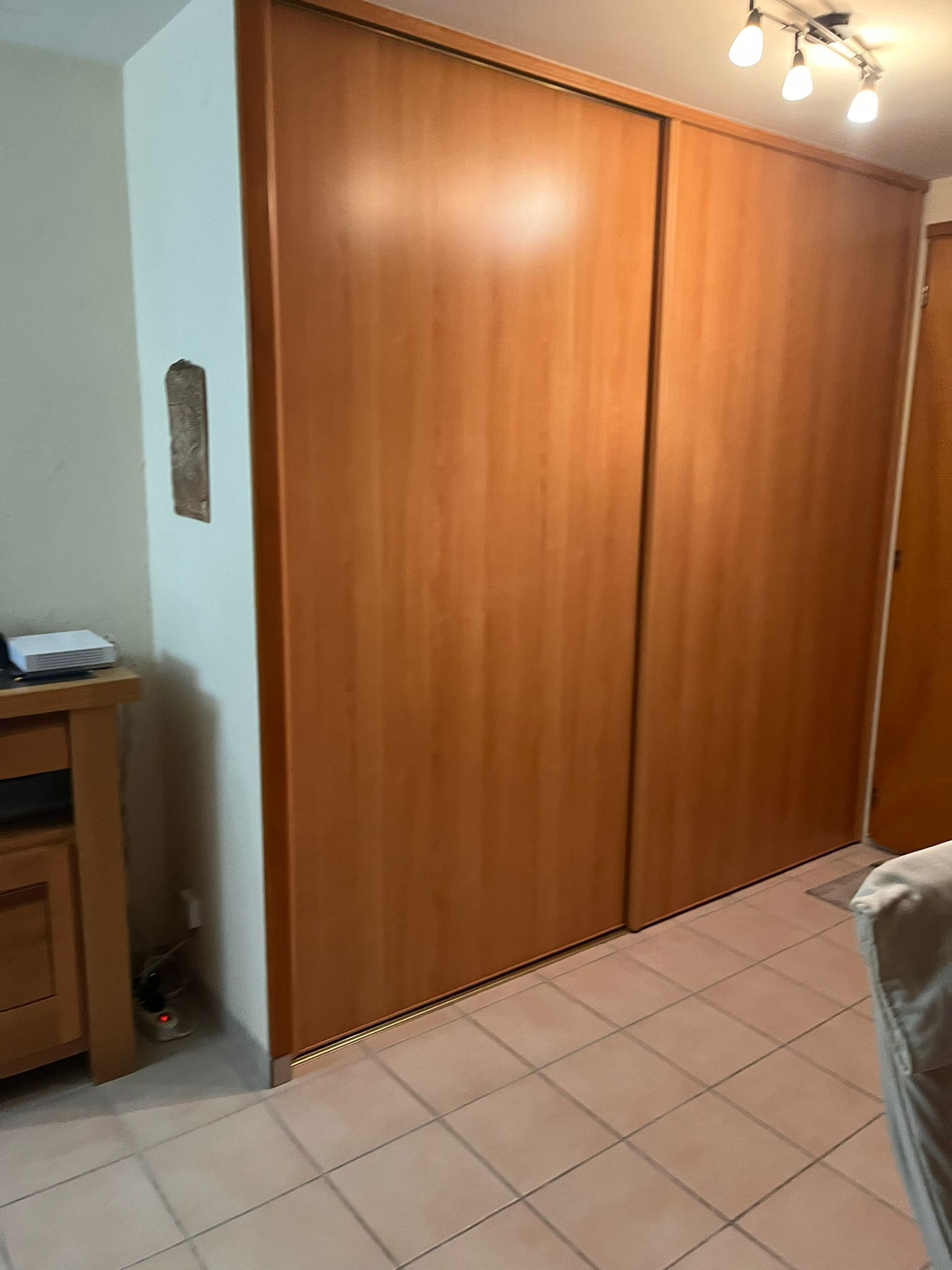 Une chambre avec une grande armoire en bois à portes coulissantes.