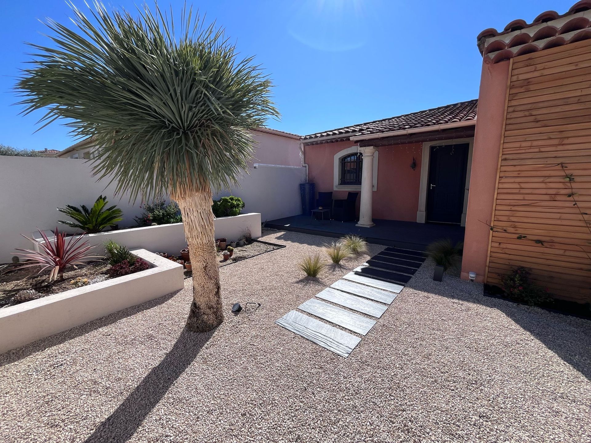 Une maison avec un palmier devant