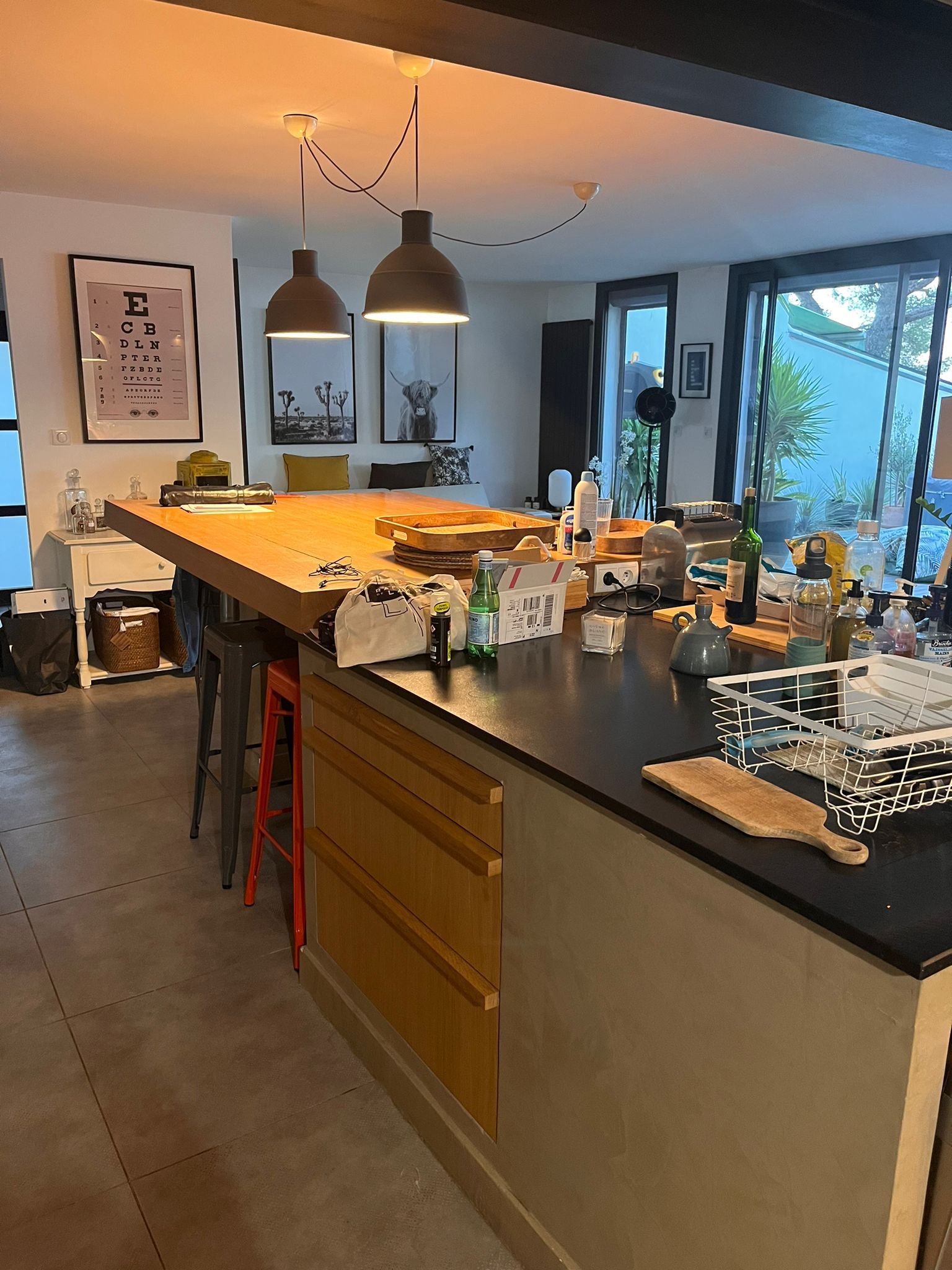 Une cour arrière avec un cabanon et une poubelle.