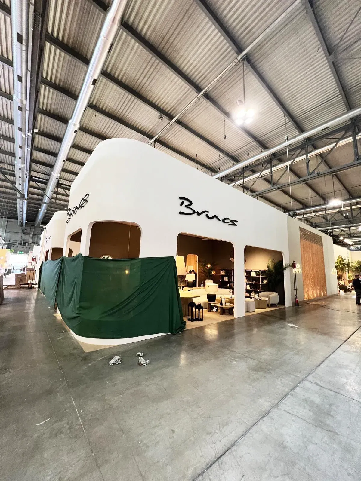 Un edificio grande con una pared blanca y una lona verde que lo cubre.