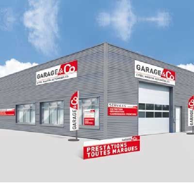 Garage & Co, atelier de réparation automobile avec enseigne rouge et blanche ; bâtiment gris, ciel bleu.