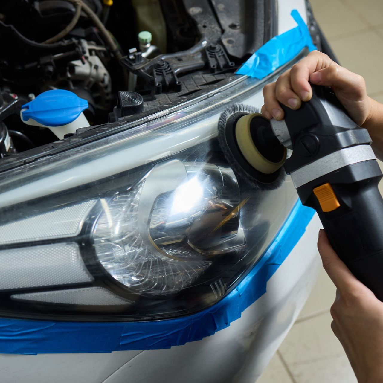 Una persona está puliendo los faros de un coche.