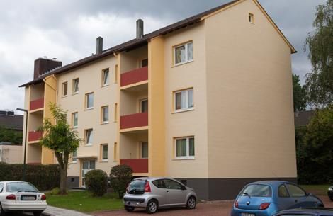 Ein Gebäude mit davor geparkten Autos an einem bewölkten Tag