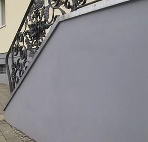 An der Seite der Treppe befindet sich ein schmiedeeisernes Geländer.