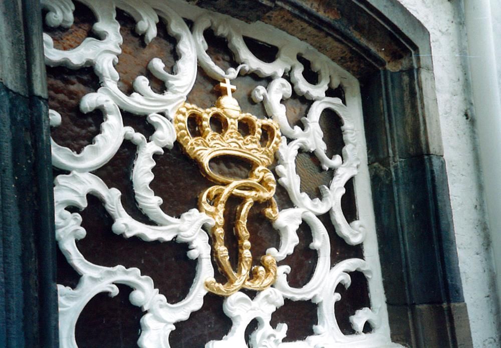 Ein gold-weißes Emblem mit dem Buchstaben t darauf