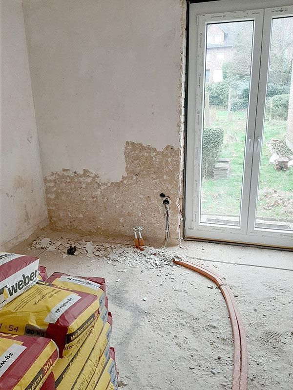 Ein Raum mit einem Fenster und einem Stapel Taschen auf dem Boden.