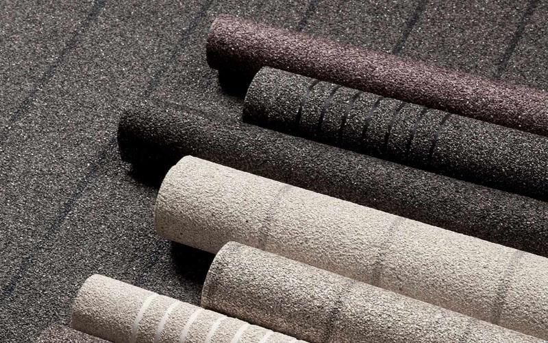 Ein Stapel Tapetenrollen liegt übereinander gestapelt auf dem Boden.