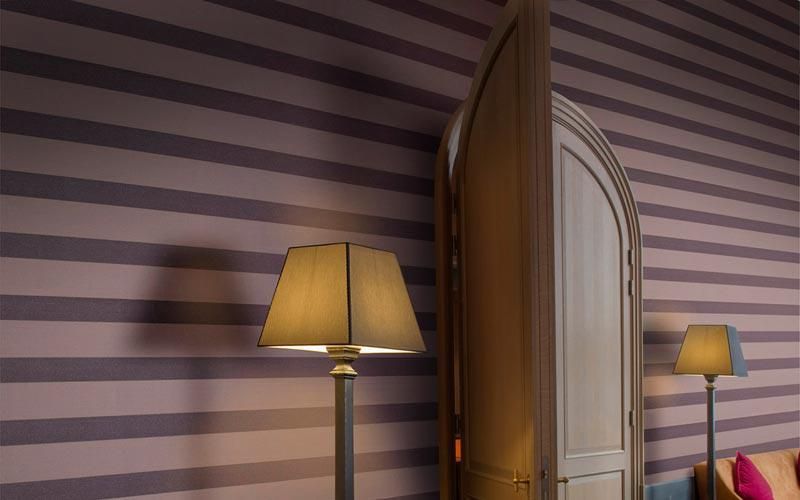 Eine Lampe steht vor einer gestreiften Wand