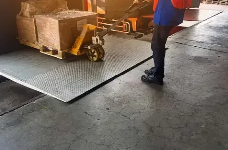 Un hombre empuja una transpaleta con cajas en un almacén.
