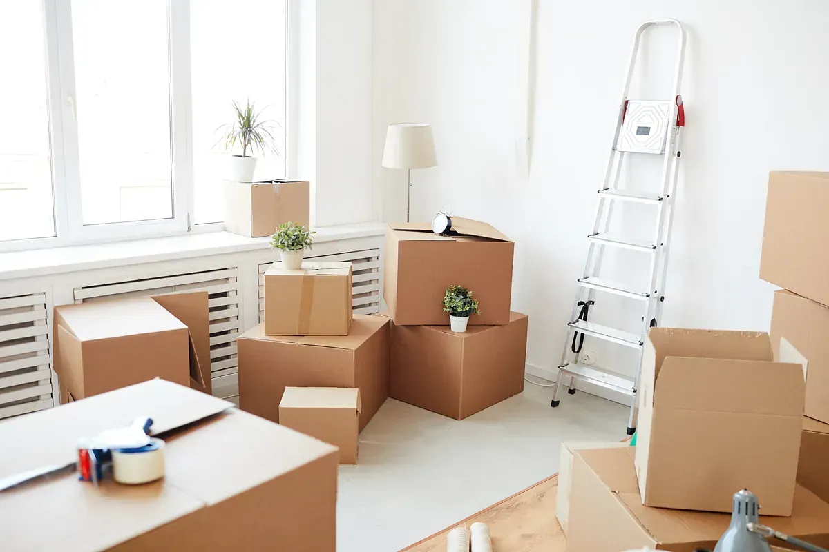 Una sala de estar llena de cajas de cartón y una escalera.