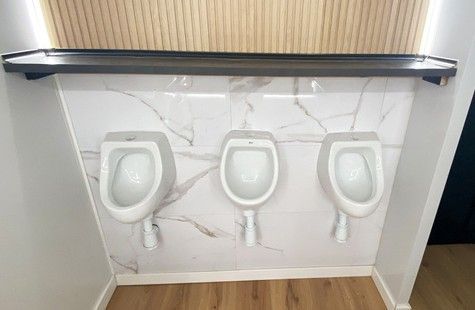 Un baño con inodoro y dispensador de toallas de papel.