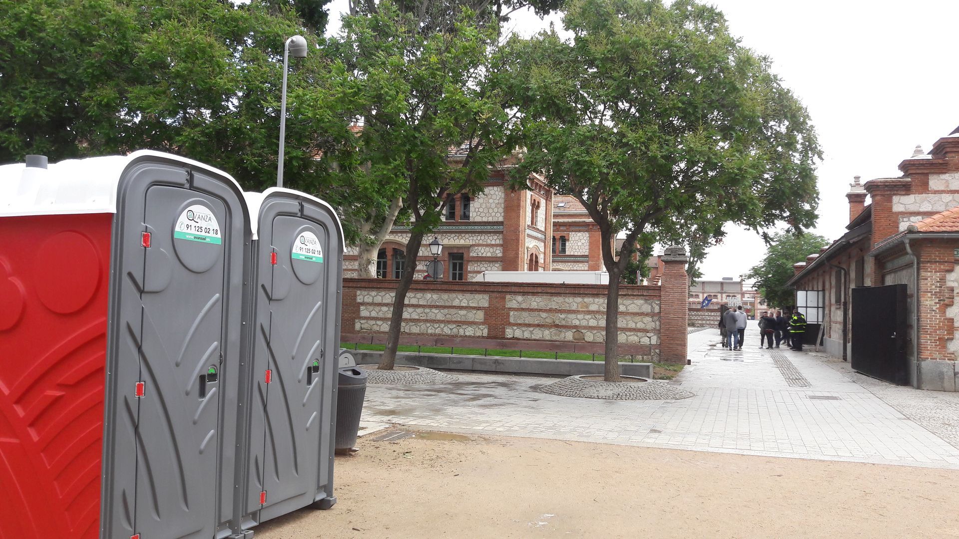 Un par de baños portátiles están ubicados uno al lado del otro en un parque.