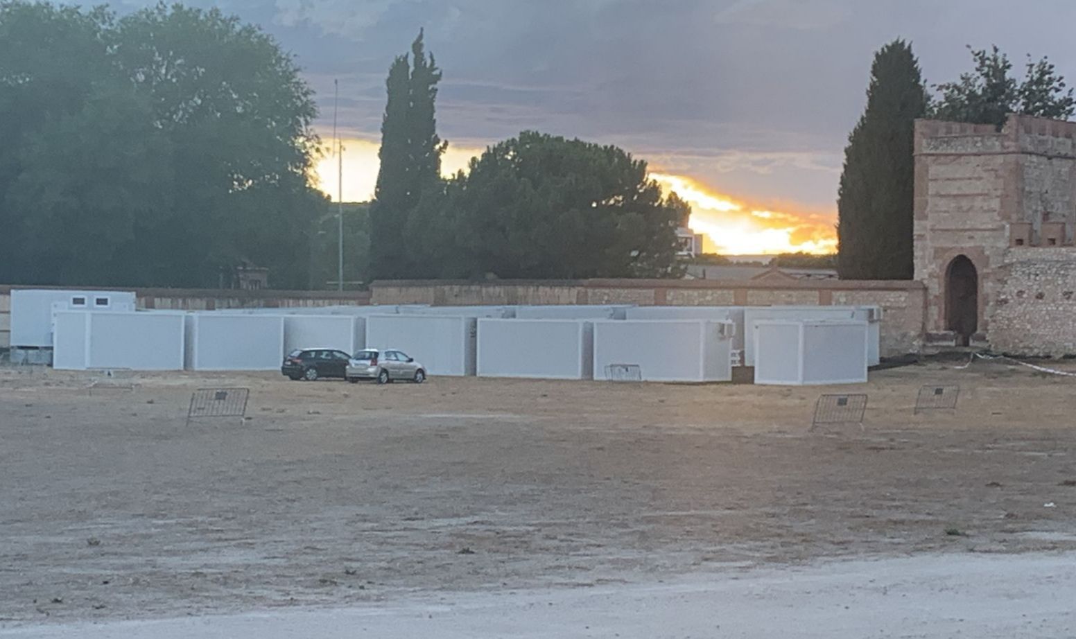 Una fila de cajas blancas se encuentran encima de un campo de tierra.