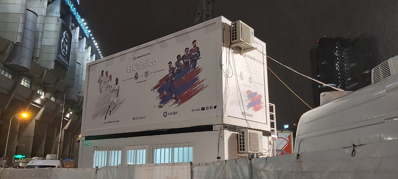 Un gran edificio blanco con un gran cartel publicitario en el costado.