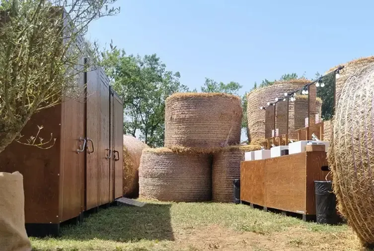 Un montón de fardos de heno están apilados uno encima del otro en un campo.