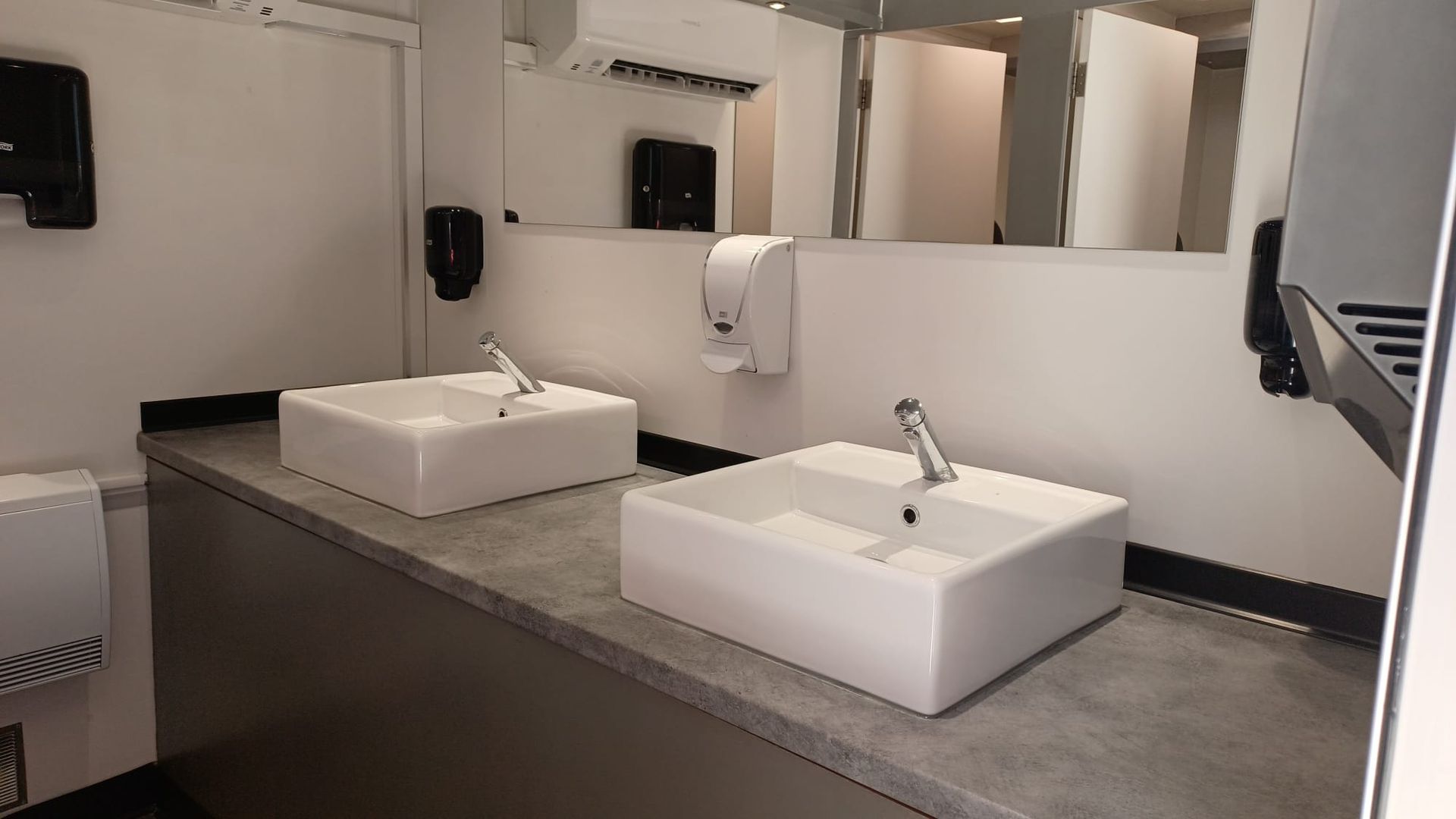 Un baño con dos lavabos y un espejo.
