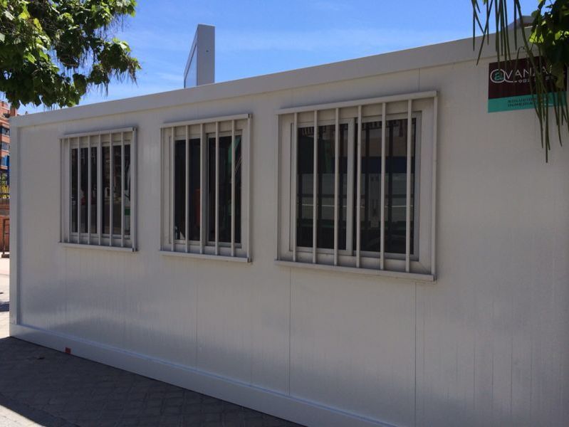 Un edificio blanco con muchas ventanas y rejas en las ventanas.