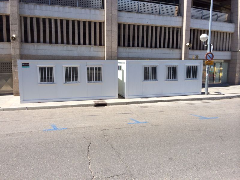 Un edificio blanco con muchas ventanas está al costado de la carretera.