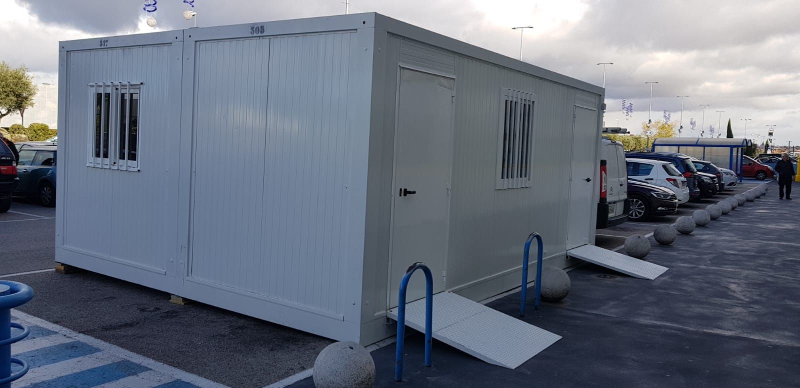 Un edificio blanco con una rampa en un estacionamiento.