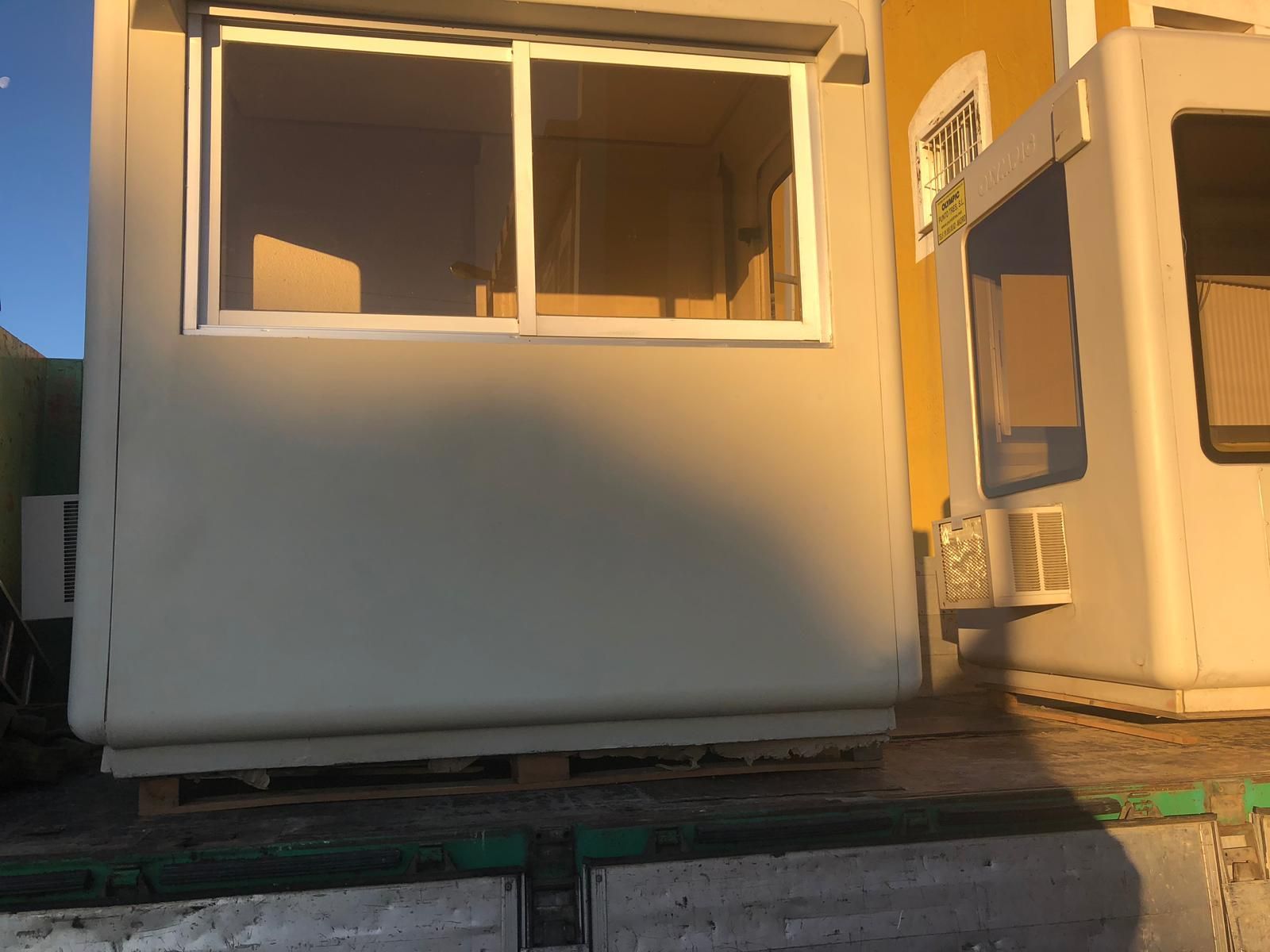 Un edificio blanco con una ventana y un edificio amarillo al fondo.
