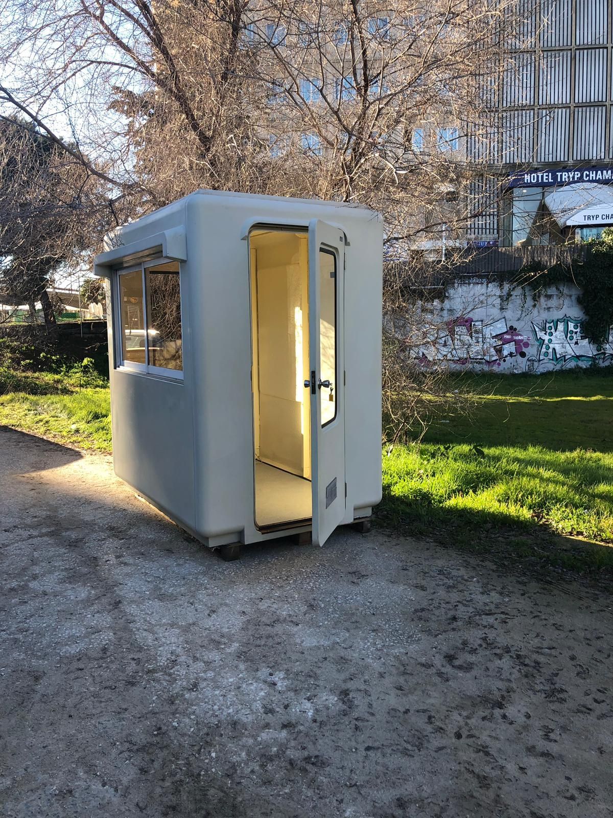Un pequeño edificio blanco está situado en el medio de un parque.