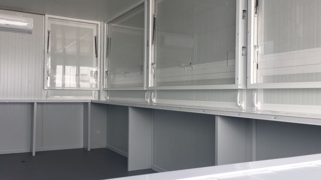 Una gran habitación vacía con muchas ventanas y mesas.