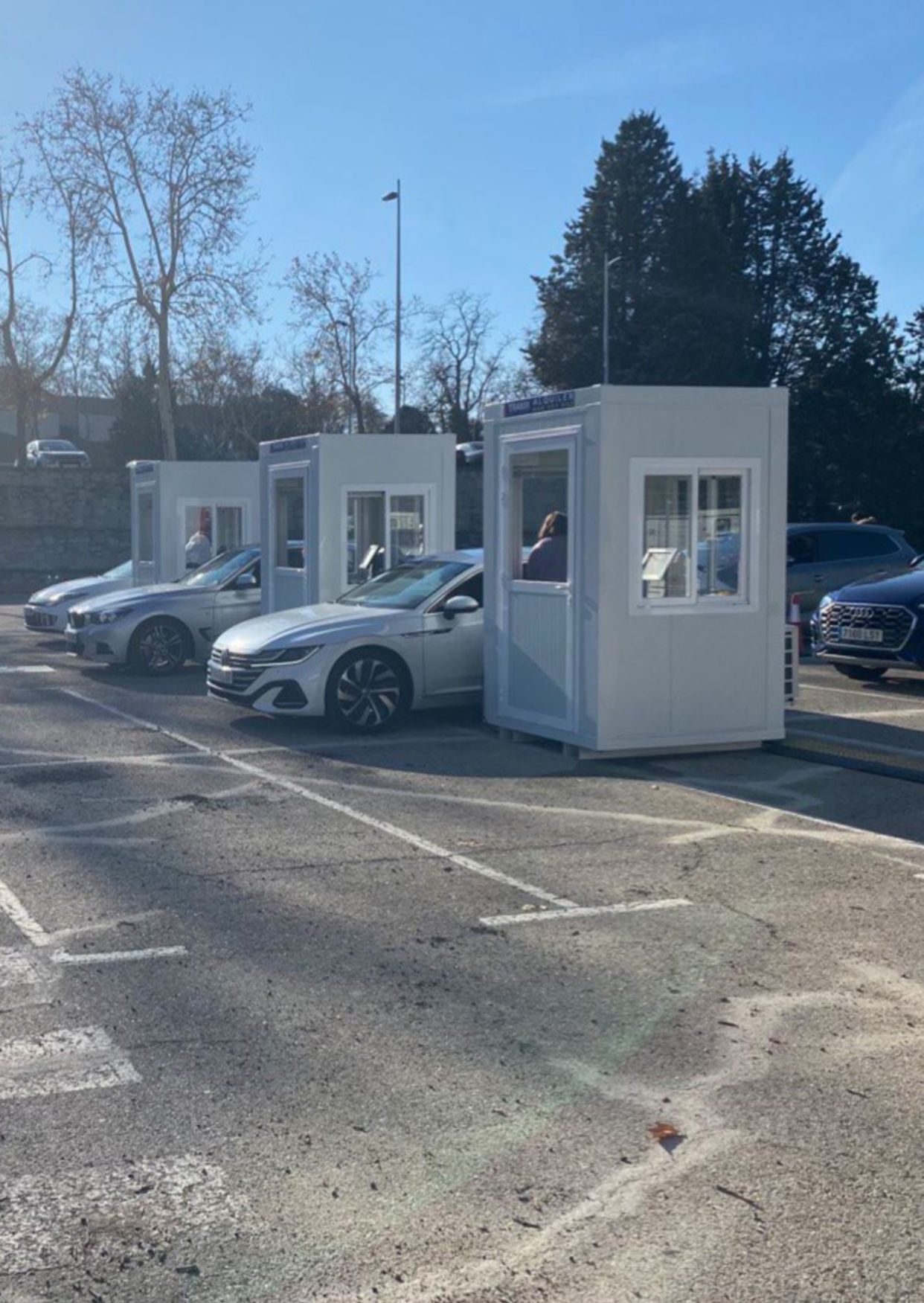 Una fila de coches blancos están estacionados en un estacionamiento.