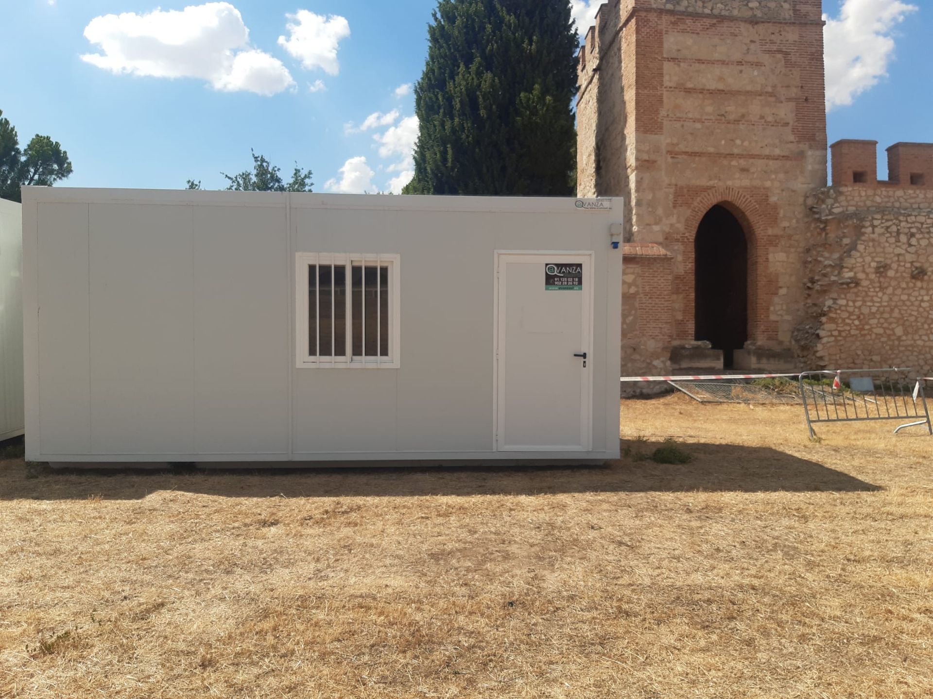Un grupo de personas camina frente a una gran carpa blanca en un estacionamiento.