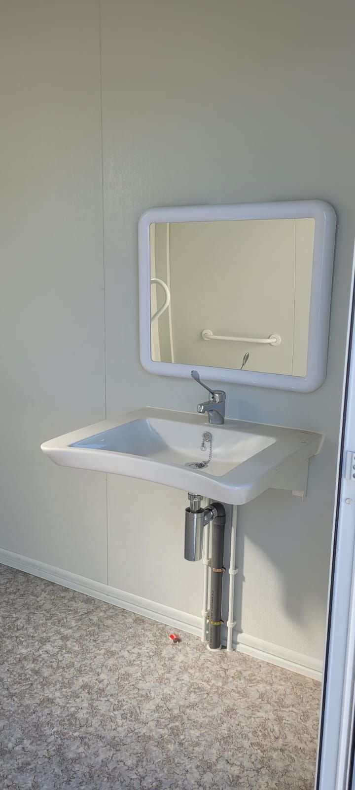 Un baño con un lavabo y un espejo en la pared.