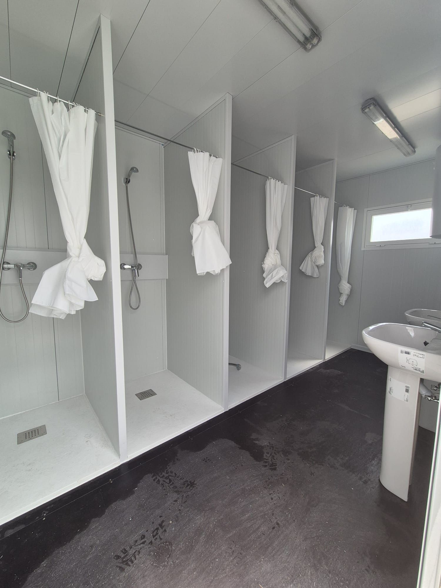 Una fila de tiendas blancas están alineadas en un parque