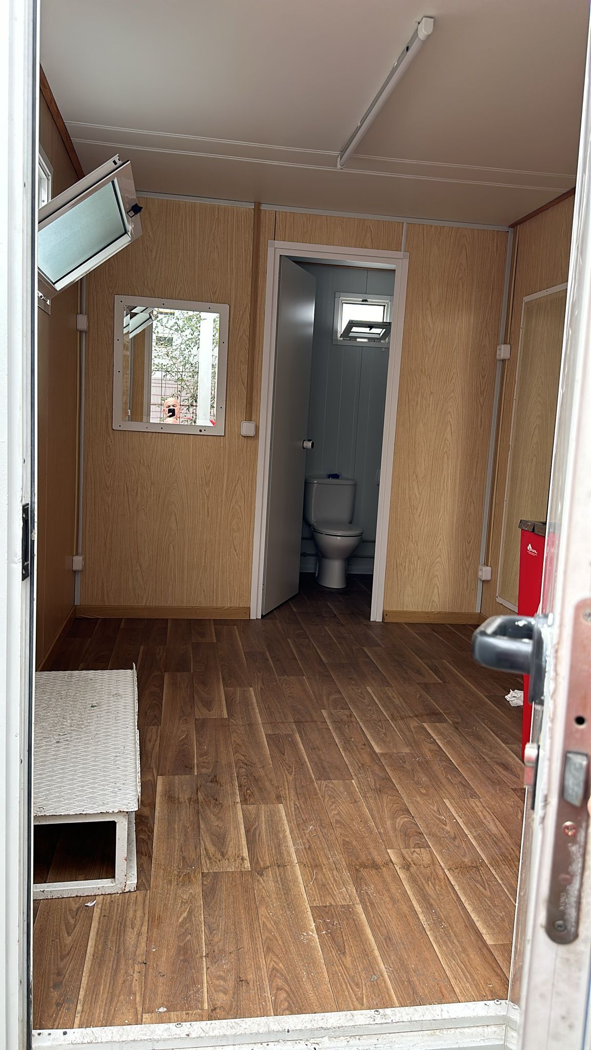 Una habitación con un inodoro y un espejo en la pared.