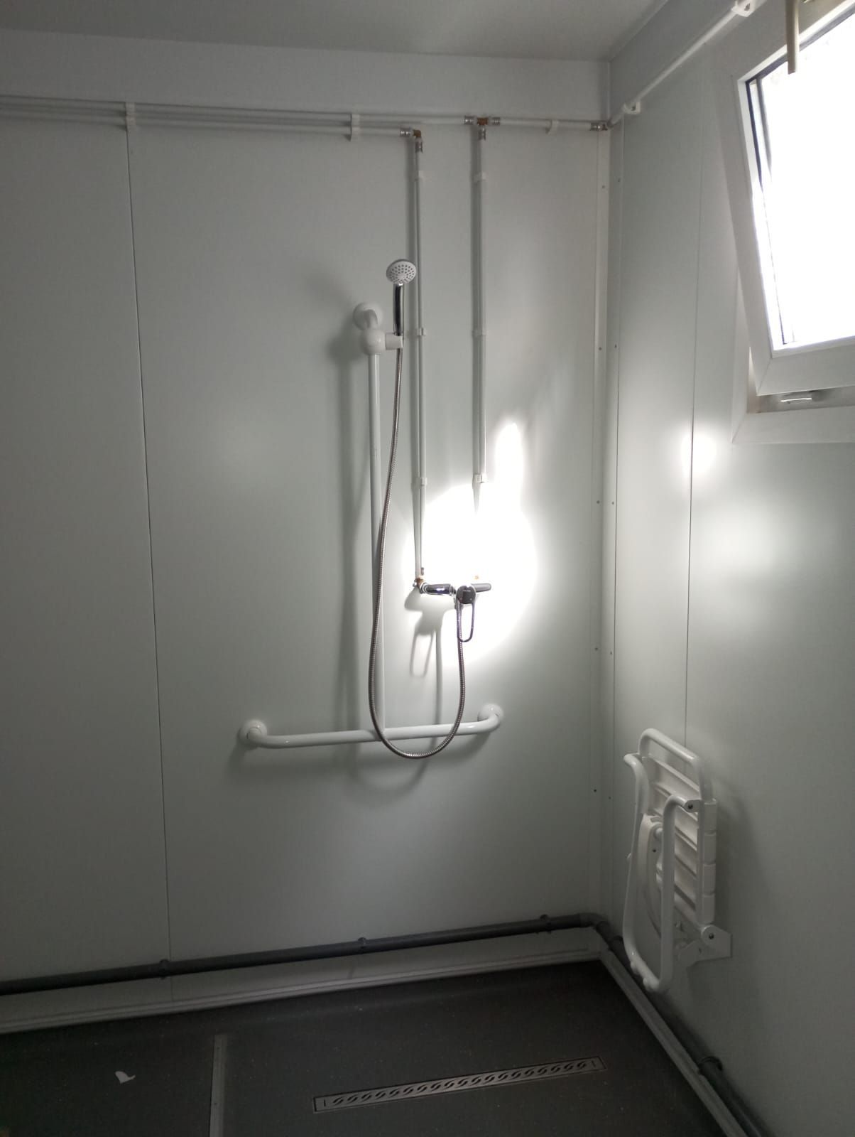 Un baño con ducha y ventana.