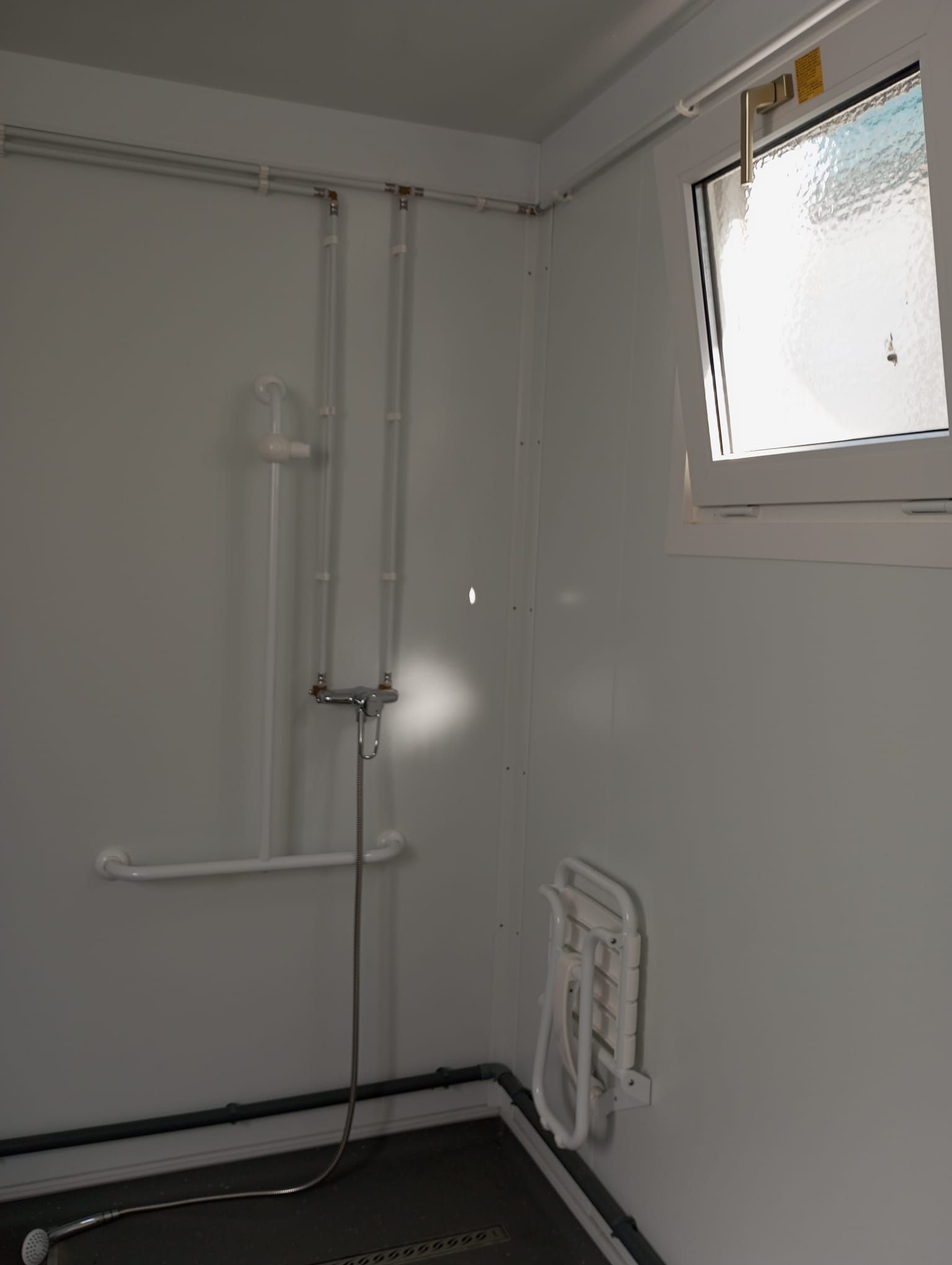 Un baño con ducha y ventana.