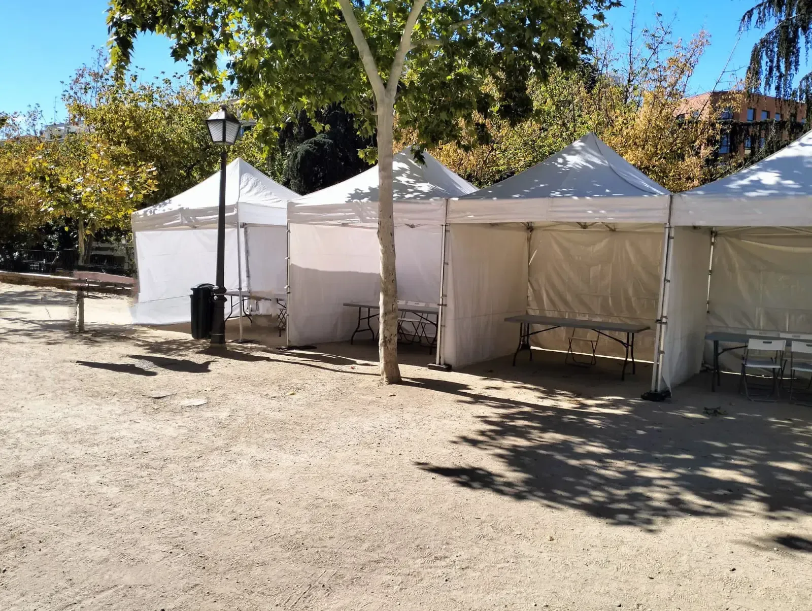 Una fila de tiendas blancas están alineadas en un parque