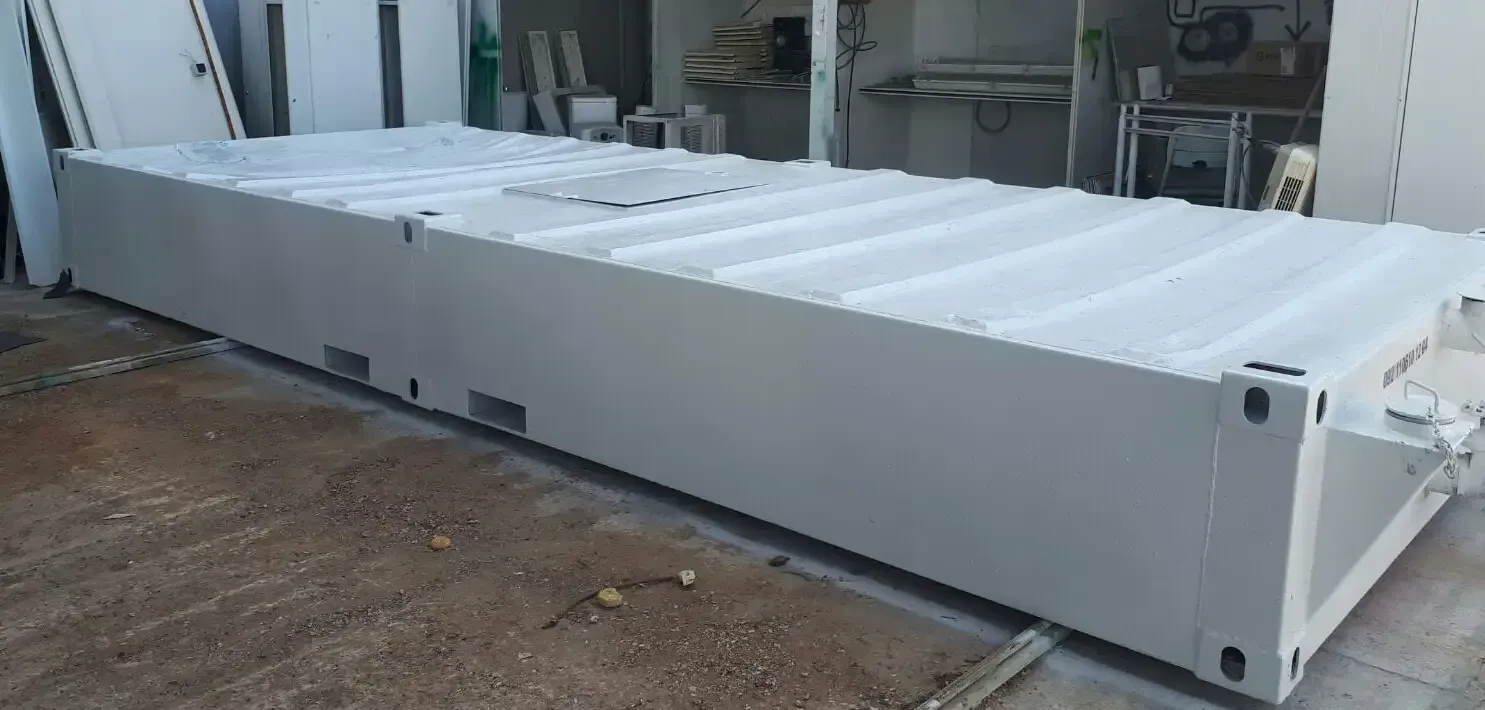 Un gran contenedor blanco se encuentra encima de un suelo de tierra.